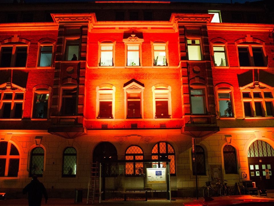 Das Hauptgebäude des KEE in der Holzhäuser Straße wird orange angestrahlt.