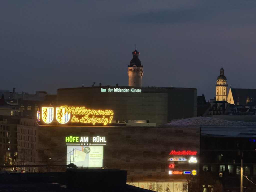 Ausblick bei Nacht aus der Gerberstraße Richtung Zentrum. Man sieht den Turm vom Neuen Rathaus, sowie die Höfe am Brühl mit dem Schriftzug "Willkommen in Leipzig".